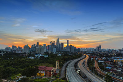 Aerial view of buildings in city against sky during sunset