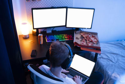 Gamer boy using laptop near table at home