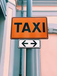 Taxi orange sign closeup in a street with natural light and copy space 