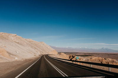 Road passing through desert against sky