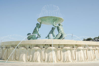 Low angle view of statue against clear blue sky