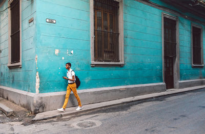 Full length of man walking on street against building