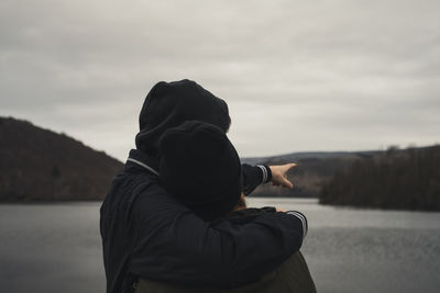 Young couple standing in front of a lake 