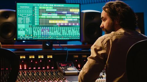 Midsection of man using sound mixer