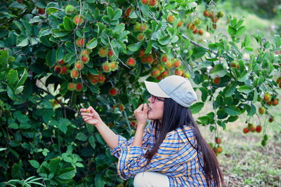 Agriculture woman sitting under rambutan tree in the orchard