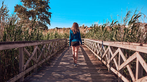 Rear view of woman on footbridge