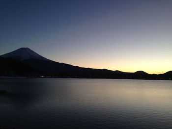 Scenic view of lake against clear sky during sunset
