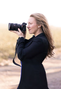 Young woman photographing camera