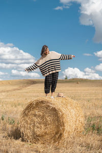 Hay bales on field against sky