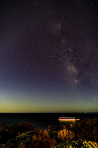 Scenic view of sea against star field at night