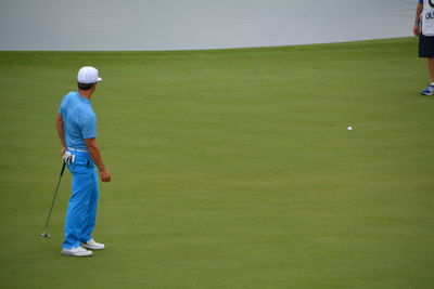 Side view of golfer standing on golf course