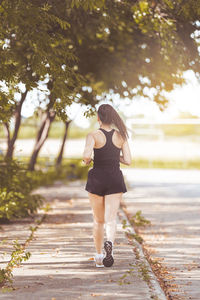 Full length rear view of woman walking on footpath