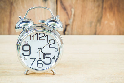 Close-up of alarm clock on wooden table