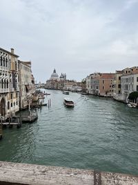 Buildings by river against sky