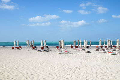 An empty beach near abu dhabi with turquoise water and umbrellas