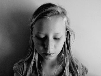 Close-up of girl looking down by wall