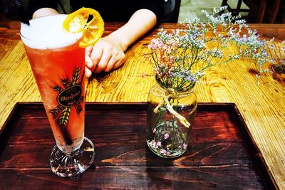 Low section of woman with drink on table