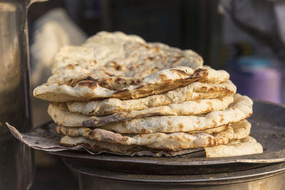 Roti pile in street food stall in marketplace of delhi, india