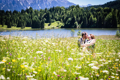 Couple romancing while sitting on grassy land