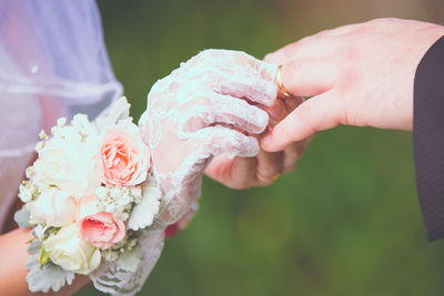 Close-up bride wearing ring to groom