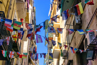 Low angle view of flags hanging against buildings