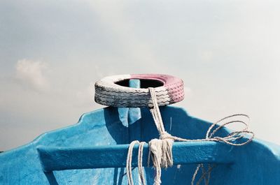 Close-up of rope tied to bollard against sky