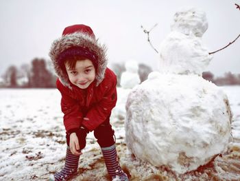 Portrait of smiling boy standing in snow