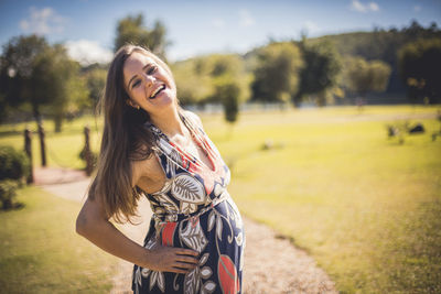 Portrait of smiling young woman standing on field