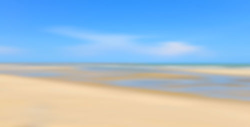 Scenic view of beach against blue sky