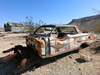 Abandoned truck on landscape against clear sky