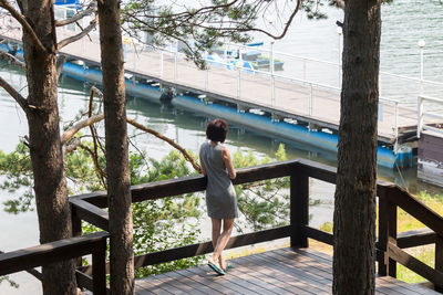 A brunette woman stands at the pier waiting for the ship.