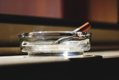 Close-up of cigarette with ashtray on table