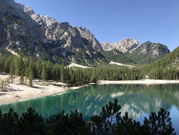 Scenic view of lake and mountains against clear blue sky