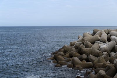 Rocks on sea shore against sky