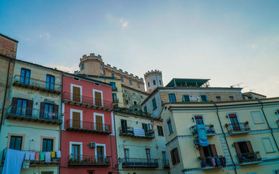 Low angle view of buildings in town against sky