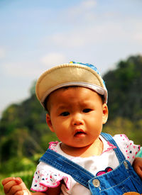 Portrait of cute boy wearing cap against sky