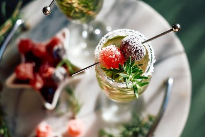 Christmas cocktail with sparkling wine, rosemary and cherry. winter holidays champagne drink.