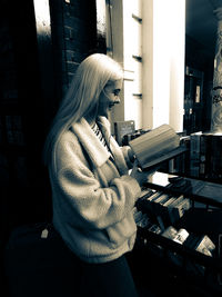 Side view of young woman standing at home