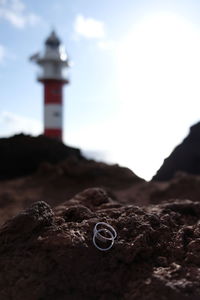 High angle view of lighthouse on rock against sky