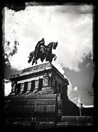 Low angle view of statue against cloudy sky