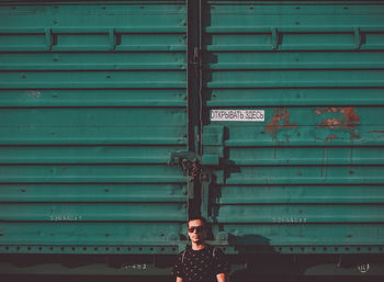 Portrait of man standing against shutter