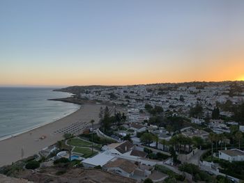 High angle view of townscape by sea against clear sky