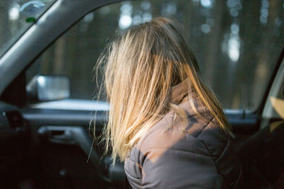 Side view of woman sitting in car