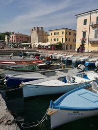 Boats moored at harbor against sky