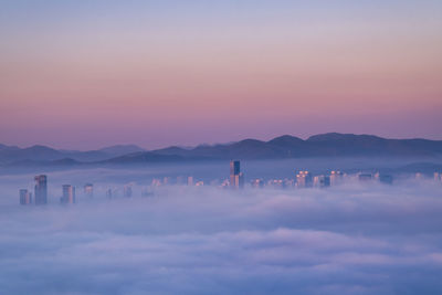 Scenic view of city against sky during sunset