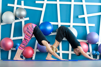 Side view of man and woman exercising in health club