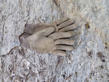Close-up of gloves on rock