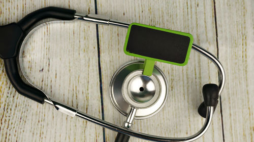 Stethoscope with blank board on wooden table