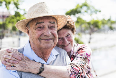 Portrait of happy senior with his smiling wife in the background