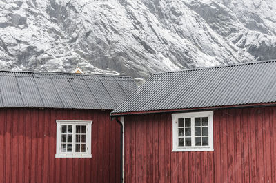 Sea cottages in front of snow covered mountain